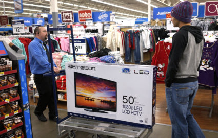 A Walmart employee helps a customer with a 50" TV on sale for $218 on Black Friday in Broomfield