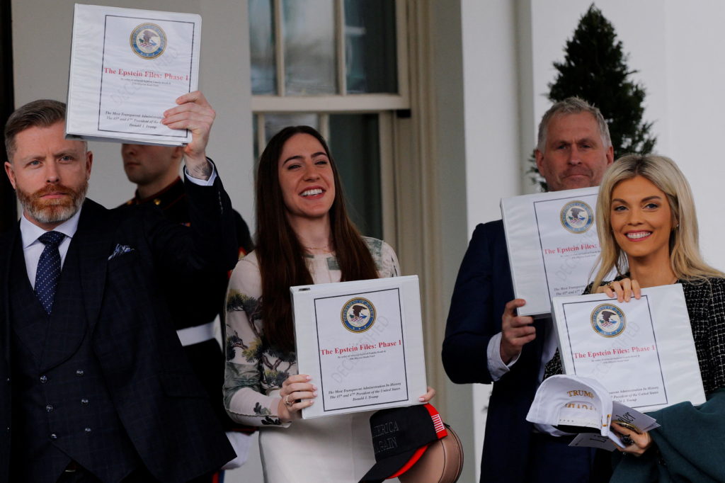 FILE PHOTO: People walk out of the West Wing and show "The Epstein Files: Phase 1" binders, in Washington, D.C.