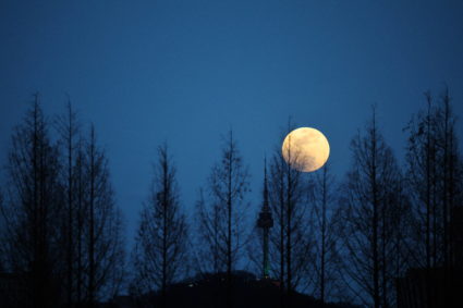 A full moon rises behind N Seoul Tower in Seoul