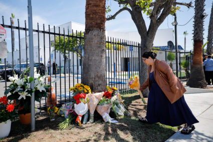 Women comfort each other outside the Islamic Centre of San Diego the morning following a shooting, in San Diego