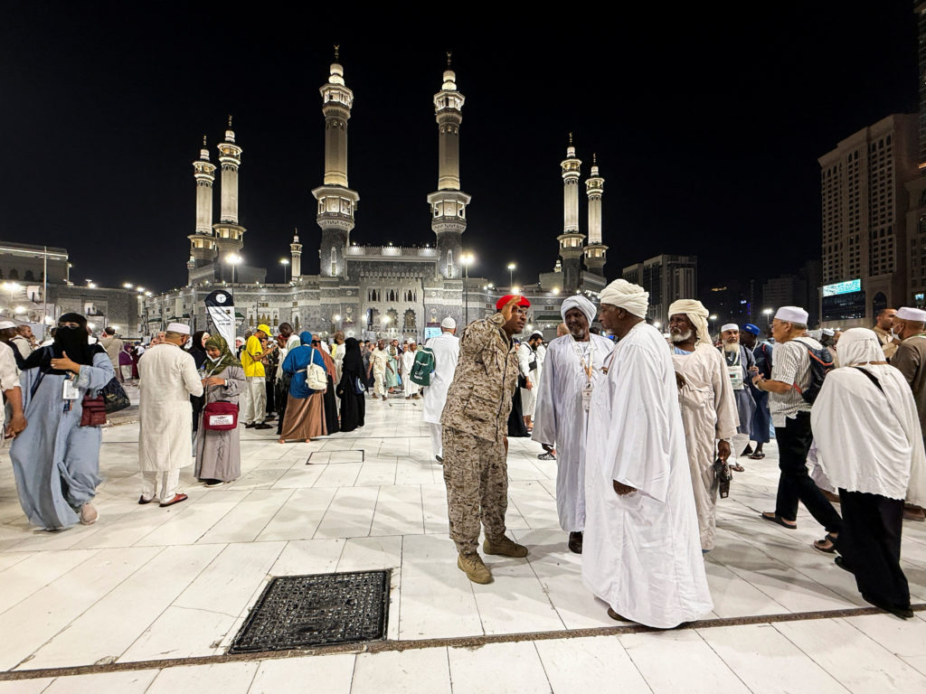 Saudi security officer speaks to Muslim pilgrims at the Grand Mosque, ahead of the annual Hajj pilgrimage, in the holy cit...