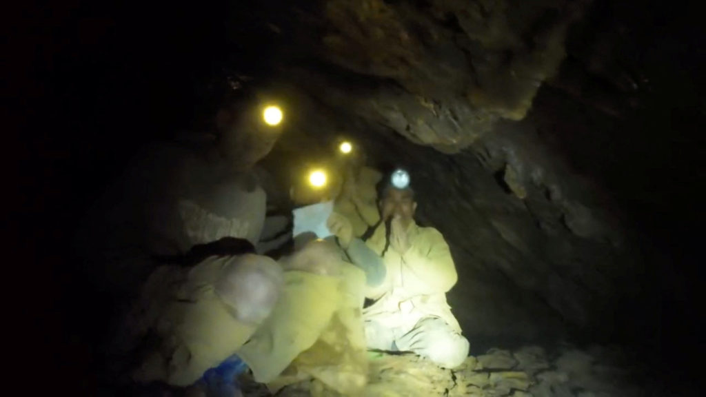 People trapped inside a cave react as they meet a rescuer, in Xaisomboun Province