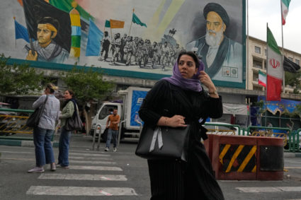 A woman crosses a street in Tehran