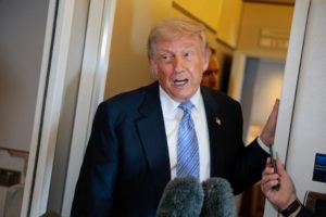 FILE PHOTO: U.S. President Donald Trump speaks to members of the media on board Air Force One, following his visit to China