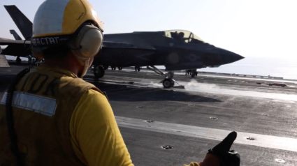 still image released by U.S. Central Command (CENTCOM) shows shows a flight deck crew member signaling an F‑35 jet on an a...