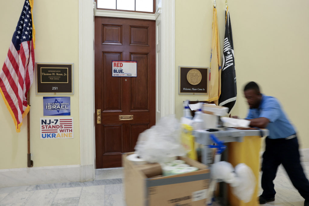 A worker passes the office door of U.S. Rep. Kean on Capitol Hill in Washington
