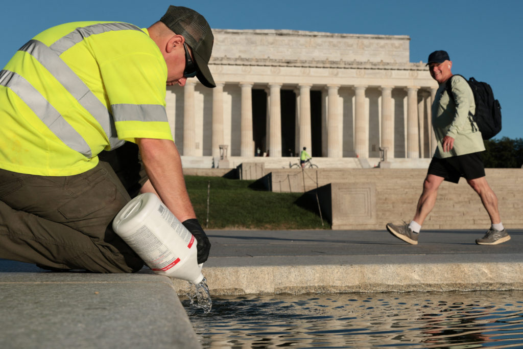 U.S. National Park Service workers dump bottles of hydrogen peroxide in the Lincoln Memorial Reflecting Pool in Washington
