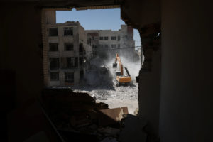 A machine operates near a residential building, which was damaged in a U.S. and Israeli strike in March, in Tehran