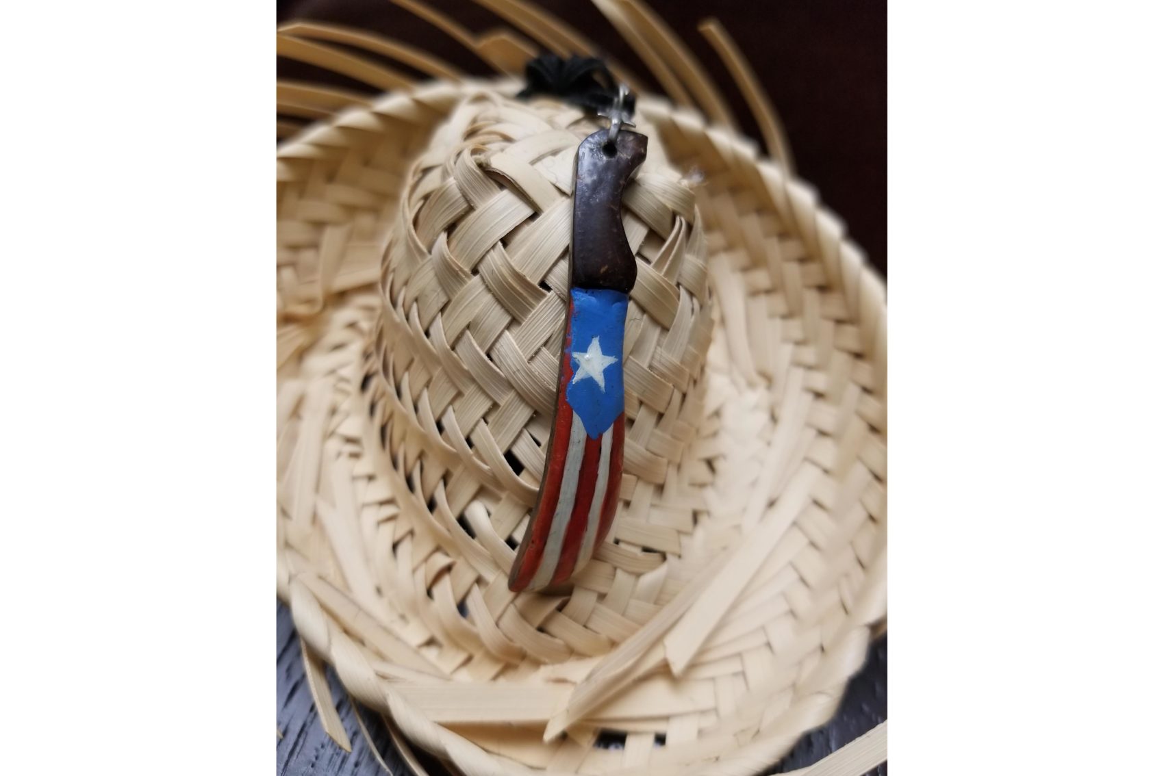 A decorative necklace with a Puerto Rican flag is painted onto a small machete, a symbol of resistance. The pava was the traditional hat worn by jíbaros, or rural farmers, who worked in the fields. Photo provided by Troche-Rodriguez