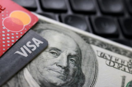 Illustration shows a U.S. dollar banknote, Visa and Mastercard cards