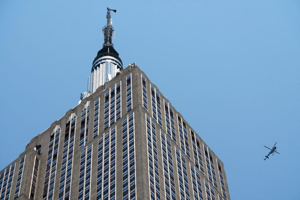 Two people display a banner atop the Empire State Building in the Manhattan borough of New York