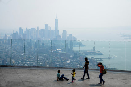 People visit the Edge observation deck as the New York City skyline and One World Trade Center are seen through a cover of...