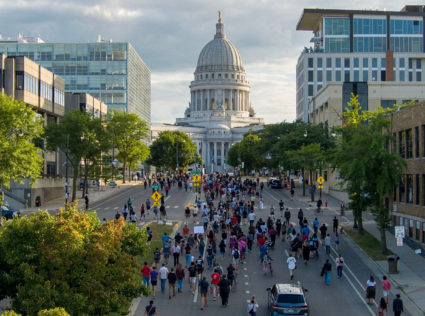 People march in protest to the Wisconsin State Capitol in response to a Madison police officer shooting and killing a man