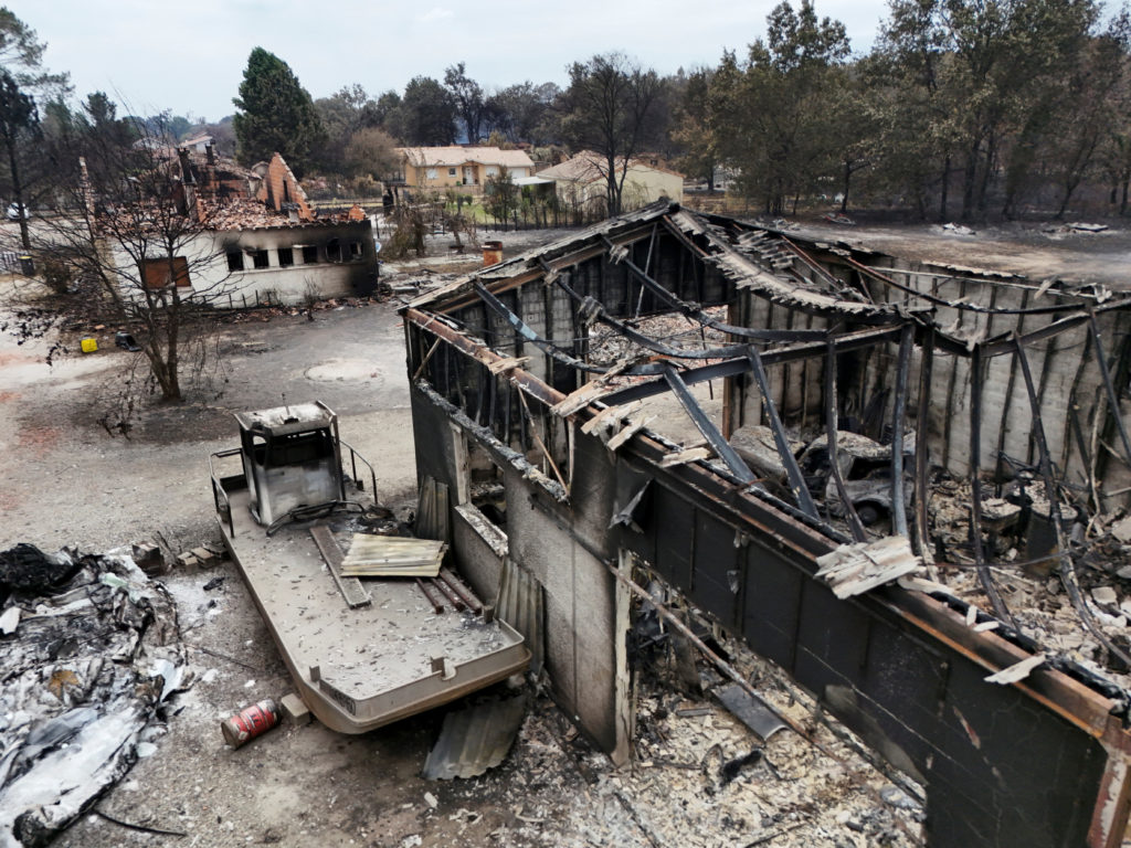 A drone view shows burnt building in an area affected by wildfire, in Le Porge