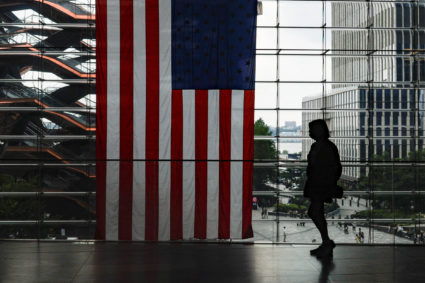 A shopper walks past a U.S. flag at Hudson Yards in New York City
