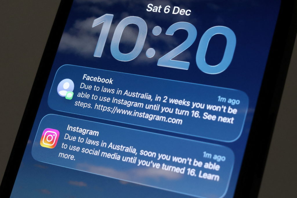 An illustration shows a Facebook message displayed on a mobile phone as Meta prepares for a new law banning social media f...