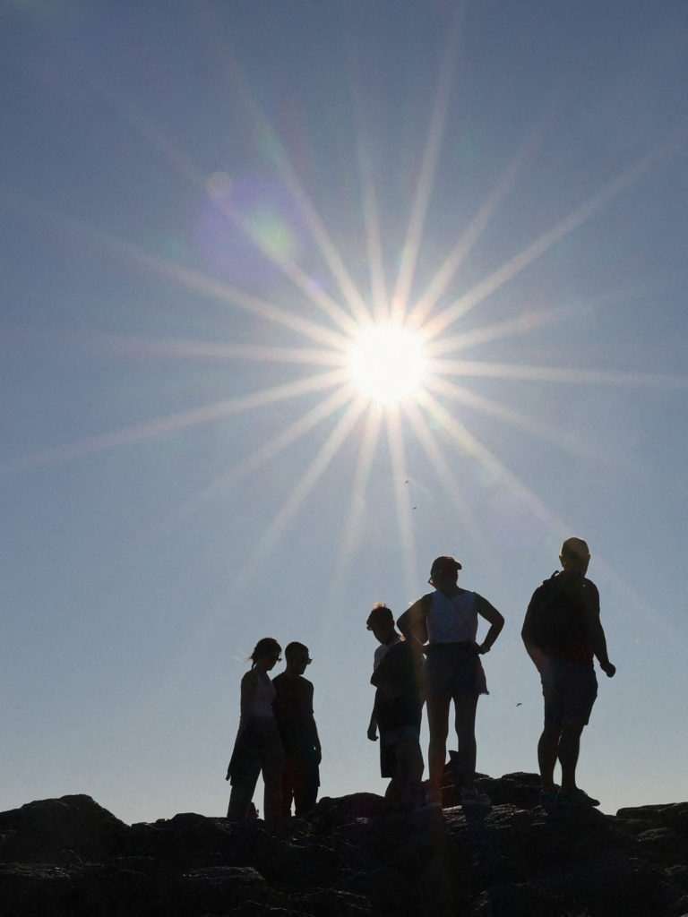 Tourists walk along Cape Fisterra the day before the solar eclipse