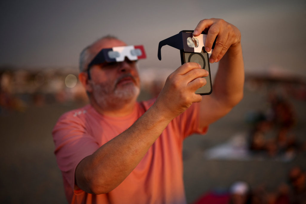 Partial solar eclipse draws eyes skyward on Italian beach