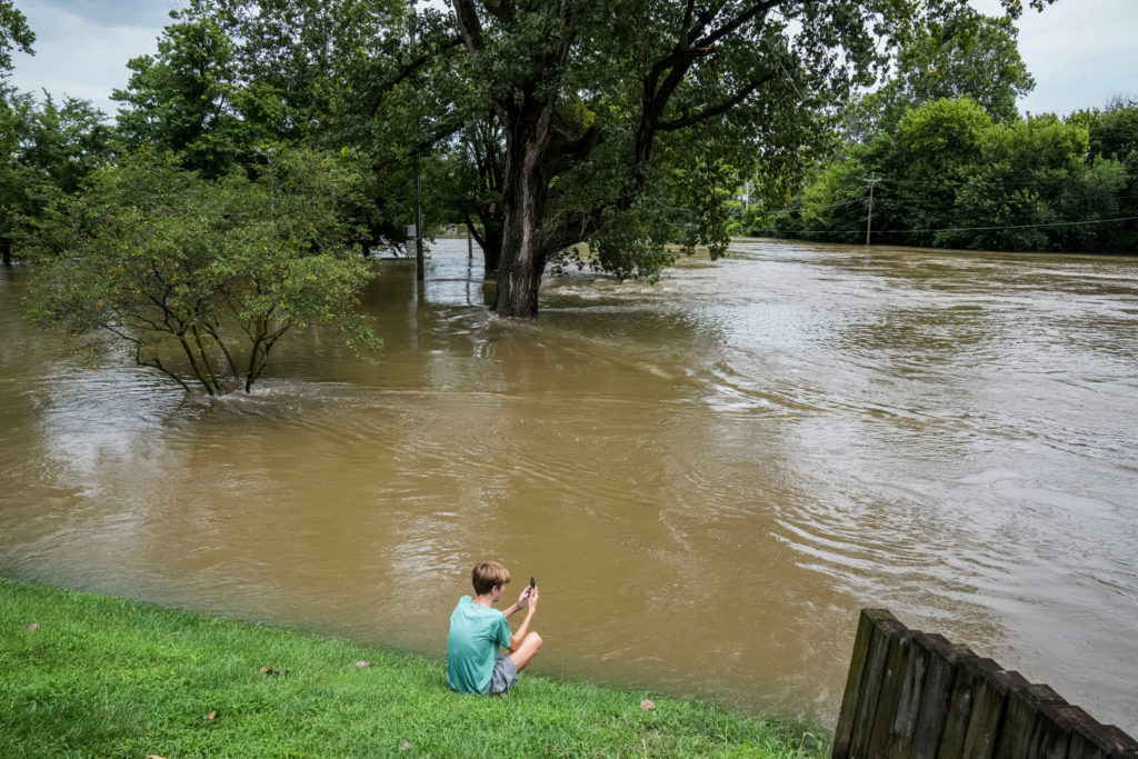 Chace Dexter films the swollen White River due to flooding after days of heavy rain in Noblesville