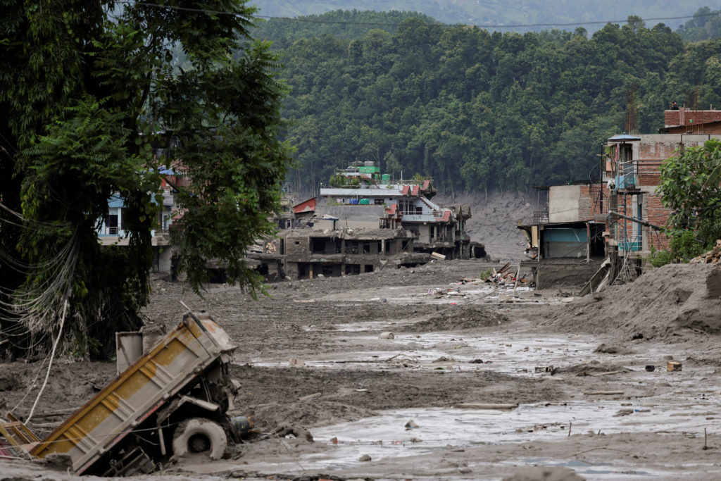 Mud covers houses and a road following a flash flood at Trishuli, Nepal