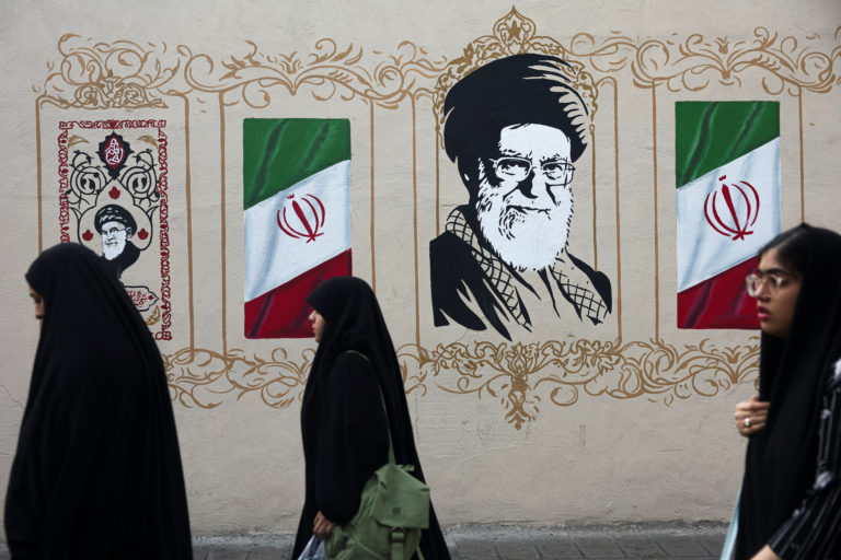 People walk by a mural depicting Iran's late Supreme Leader Ayatollah Ali Khamenei in Tehran