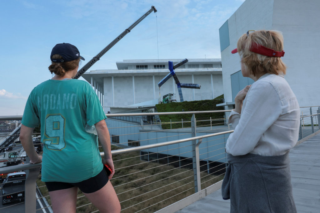 Crews work to remove the sculpture titled "Blue" by artist Joel Shapiro from the grounds of the Kennedy Center for the Per...