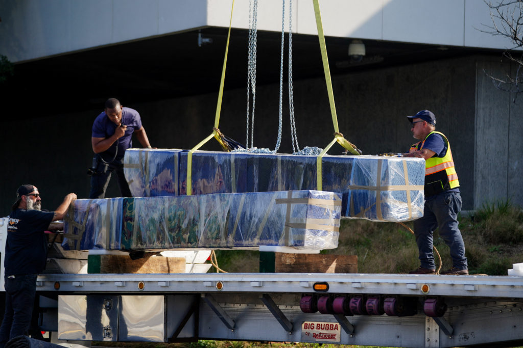 Crews work to remove the sculpture titled "Blue" by artist Joel Shapiro from the grounds of the Kennedy Center for the Per...