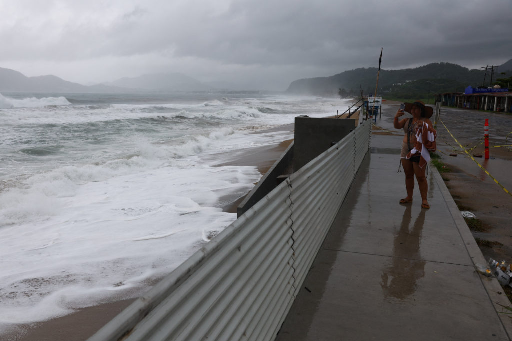 Waves crash against the waterfront in Manzanillo, Mexico, as Hurricane Simon approaches with heavy rain and strong winds.