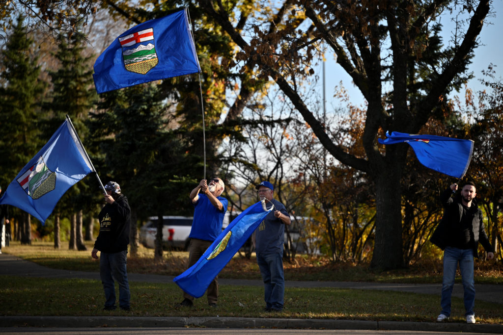 Men wave Alberta's provincial flags before Canada's Prime Minister Mark Carney attends a Forever Canadian Rally in Edmonton